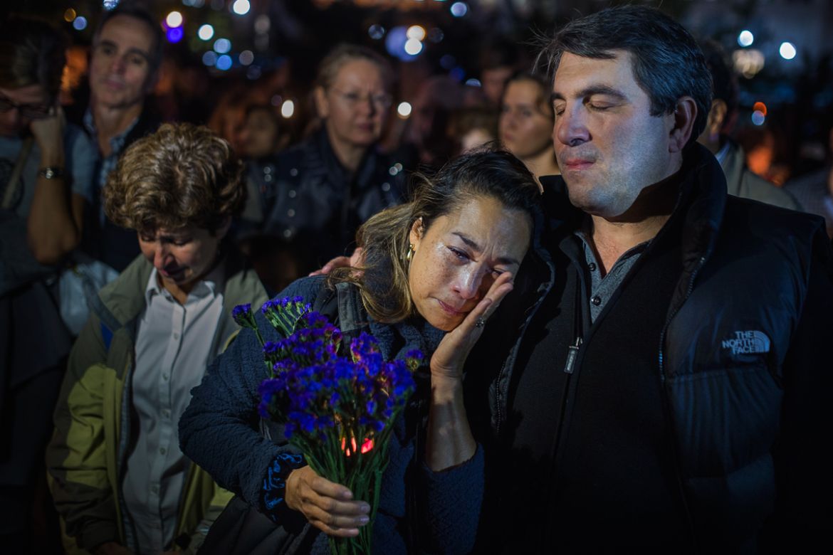 A woman cries as people gather to remember the victims of the recent truck attack during a candle light walk along the Hudson River near the crime scene on Thursday, Nov. 2, 2017, in New York. A man i