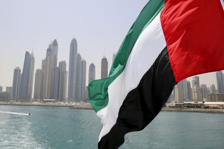 UAE flag flies over a boat at Dubai Marina,