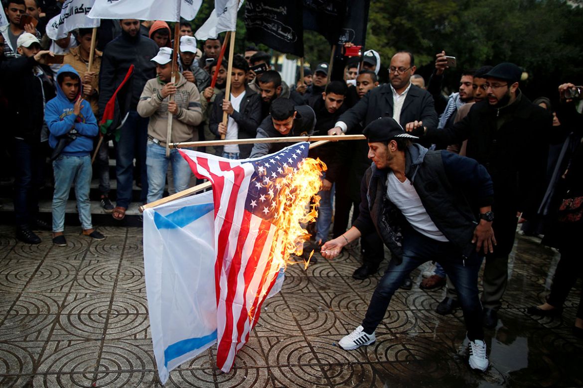 Palestinians burn an Israeli and a U.S. flag during a protest against the U.S. intention to move its embassy to Jerusalem and to recognize the city of Jerusalem as the capital of Israel, in Gaza City
