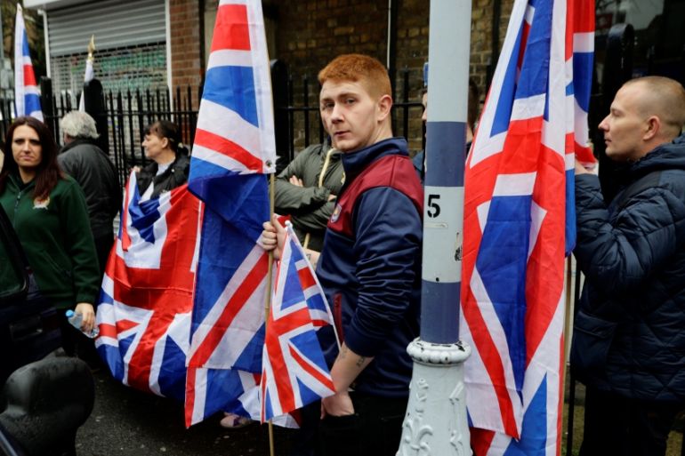 People hold the Union Flag whilst attending a Britain First rally