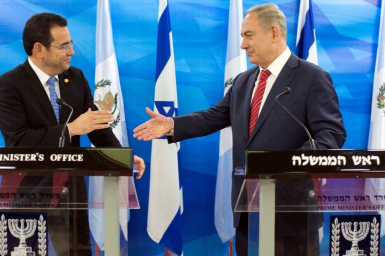 Guatemalan President Jimmy Morales and Israeli Prime Minister Benjamin Netanyahu reach out to shake hands as they deliver statements to the media during their meeting in Jerusalem