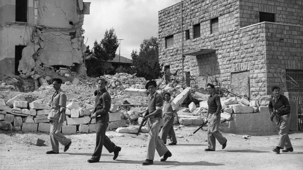 Jewish Haganah troops pass by the ruins of the Semiramis hotel on May 6, 1948 [File: AP]