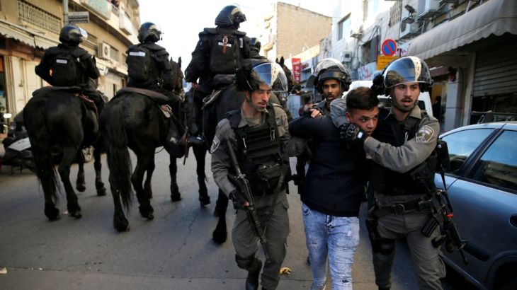 Israeli border police officers detain a protestor during a demonstration in a street in east Jerusalem