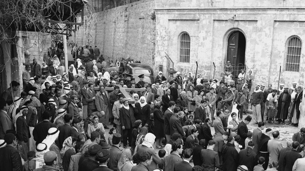 Christian Arabs, carrying a huge cross, reach the third Station of the Cross in Jerusalem on March 26, 1948 [File: AP]