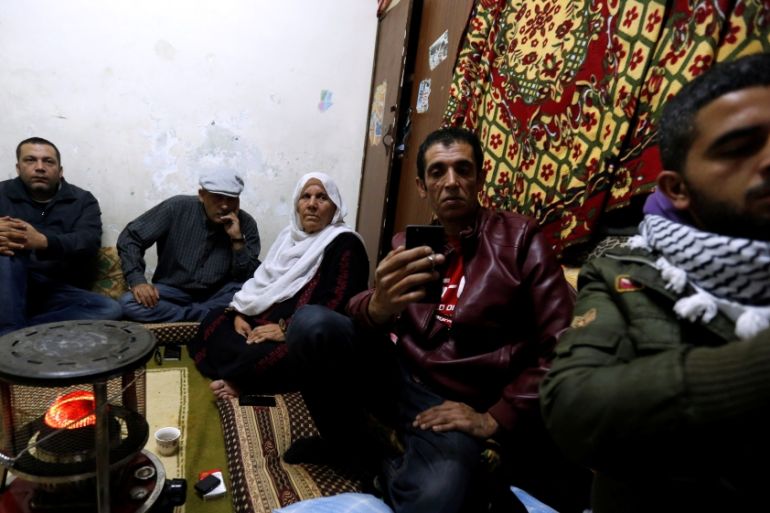 Palestinian refugee family watches a televised broadcast Trump in Amman