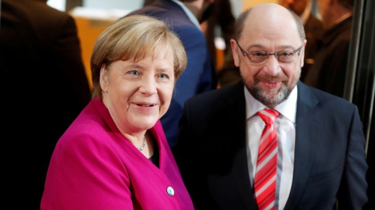 CDU leader and acting German Chancellor Merkel and SPD leader Schulz shake hands a speech before exploratory talks about forming a new coalition government at the SPD headquarters in Berlin
