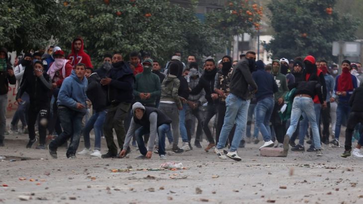Protesters throw stones during demonstrations against rising prices and tax increases, in Tebourba