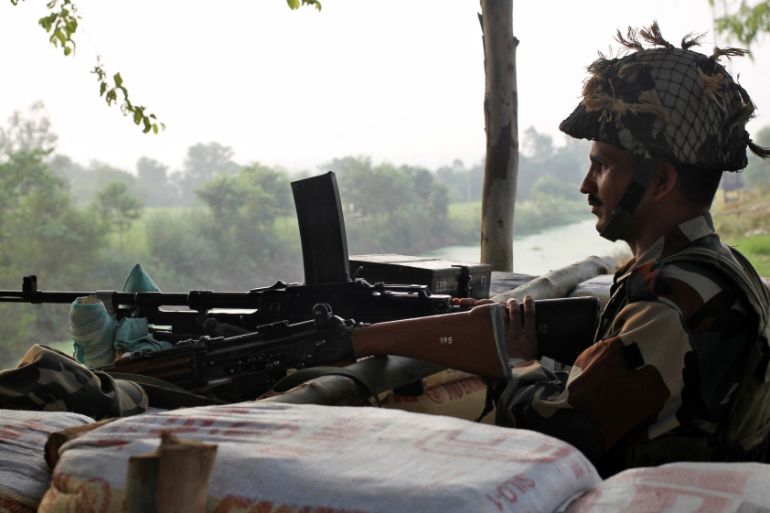 An Indian army soldier keeps guard from a bunker near the border with Pakistan in Abdullian