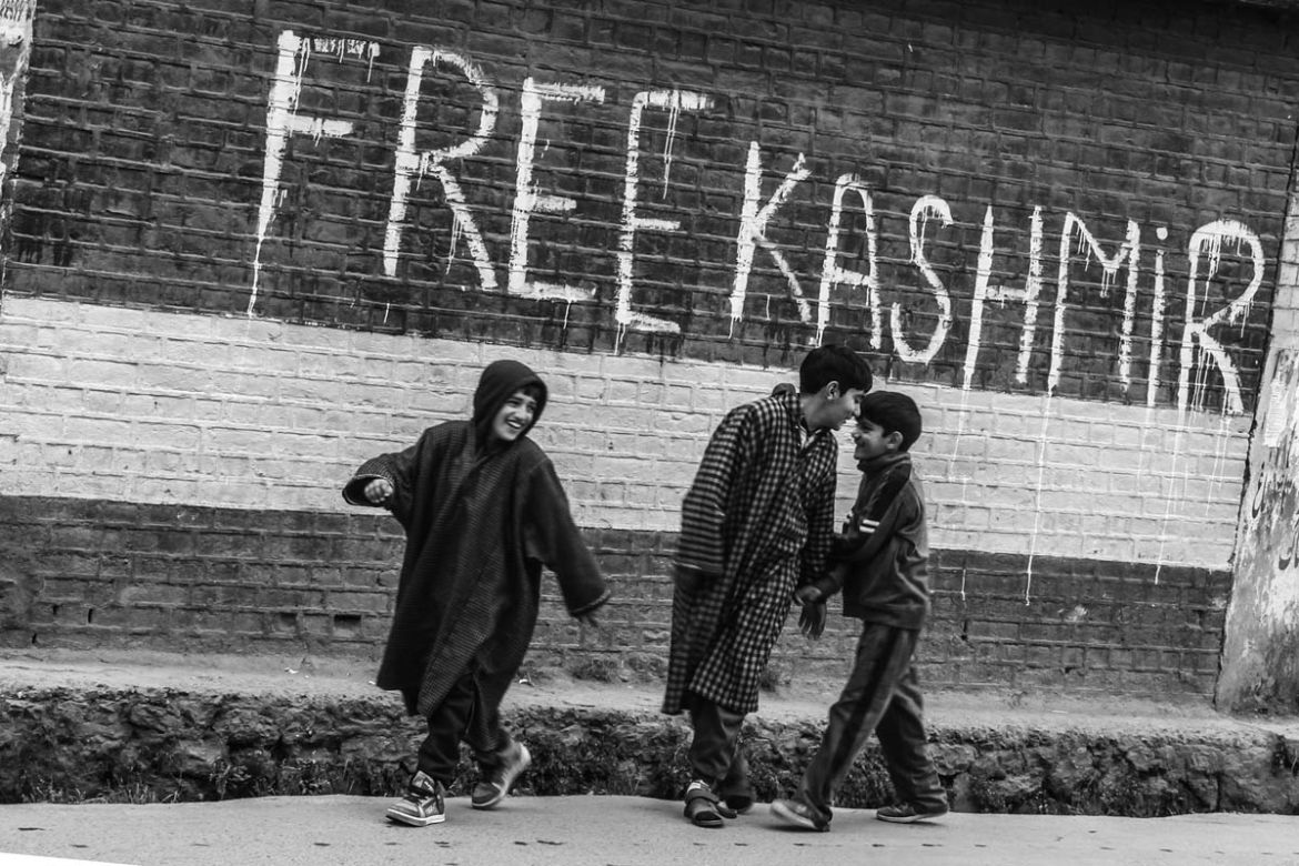 Children walking past a pro- freedom graffiti in Anantnag town, about 50 km south of Srinagar city, during a shutdown. 2016.