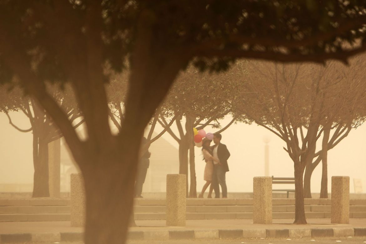 A Filipino couple take a picture during a sandstorm in the Kuwaiti capital