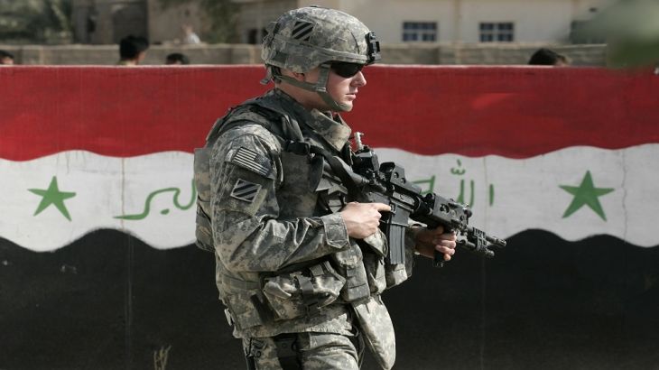 A U.S. soldier of Charlie Company 1-15 Infantry, 3rd Brigade Combat team, 3rd Infantry Division, passes next to a wall painted with the Iraqi flag during a routine patrol in Salman Pak...