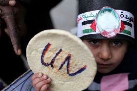 A Palestinian child holds bread during a protest against aid cuts, outside the United Nations' offices in Khan Younis in the southern Gaza Strip on January 28, 2018 [Reuters/Ibraheem Abu Mustafa]