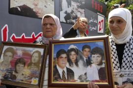 Palestinian women carry pictures of their relatives who were killed during Sabra and Shatila massacre at the mass graves in Beirut on September 18, 2009 [Ahmad Omar/AP Photo]