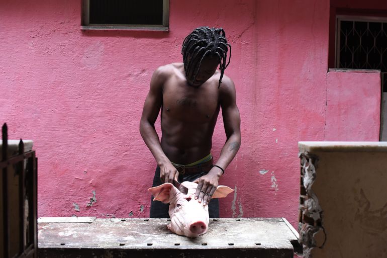 The immigrants are generally very poor and often rely on donations to eat. Here, Mbemba is seen cutting open a pig’s head they were given, so it could be eaten. The Congolese still prepare the food of