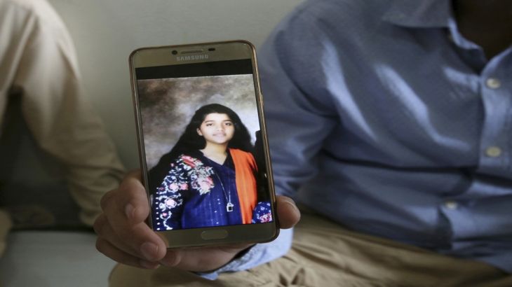 Abdul Aziz Sheikh, center, father of Sabika Sheikh, a victim of a shooting at a Texas high school, shows a picture of his daughter in Karachi, Pakistan, Saturday, May 19, 2018. [Fareed Khan/AP]
