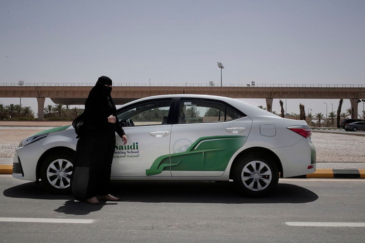 27-year old driving instructor Mabkhoutah al-Mari stands next to a test drivers car at the Saudi Driving School inside Princess Nora University in Saudi Arabia. As Saudi Arabia prepares to lift a ban