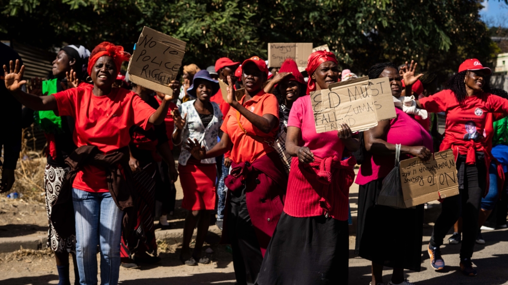 MDC Alliance supporters hold up a banner protesting against shadowy proceedings in the postal ballot and the voters' roll [Tendai Marima/Al Jazeera]