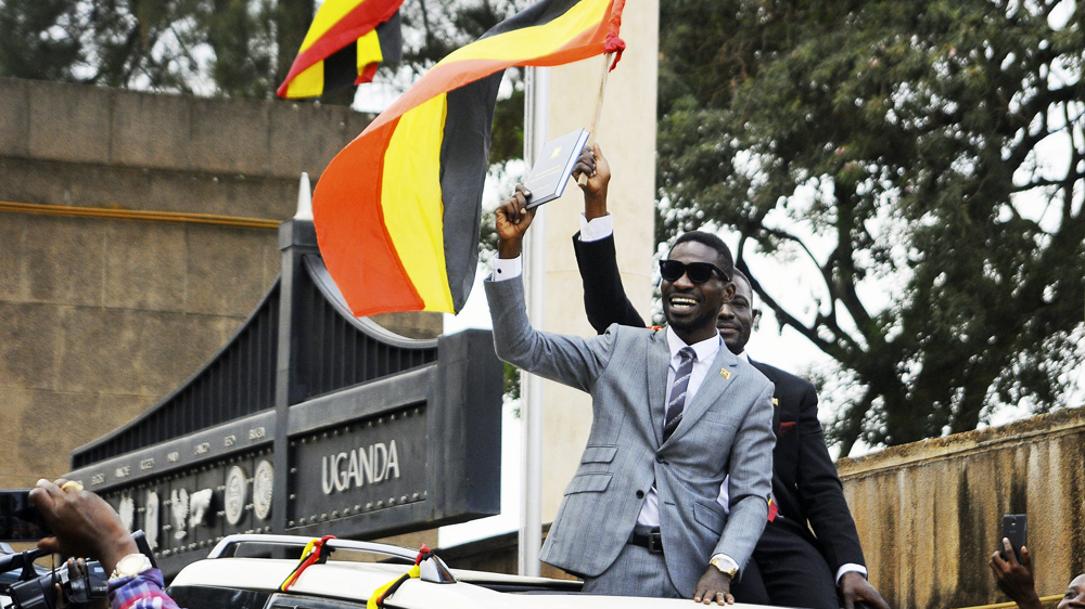 Bobi Wine gestures to supporters after being sworn in as an MP last year [Ronald Kabuubi/AP]