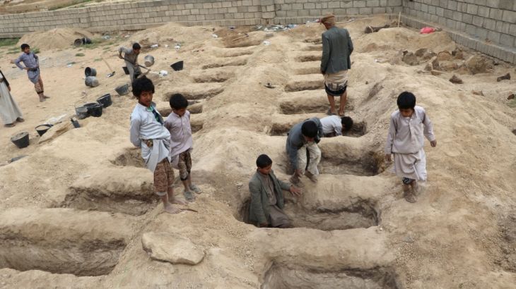 Boys inspect graves prepared for victims of Thursday''s air strike in Saada province