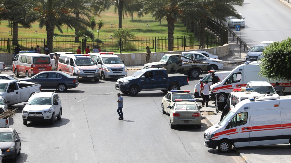 Ambulances and security vehicles near the headquarters of the National Oil Company in the Libyan capital [Hani Amara/Reuters]