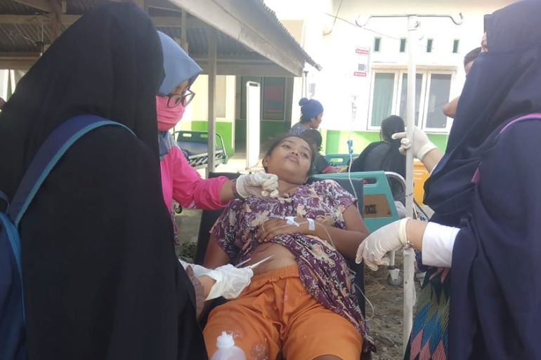 Paramedic gives treatment to an earthquake survivor outside a hospital in Donggala