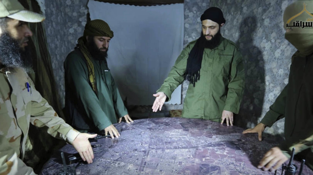 This undated file photo shows Abu Mohammed al-Joulani of the HTS, second right, discussing battlefield details with field commanders over a map, in Aleppo, Syria [File: AP]