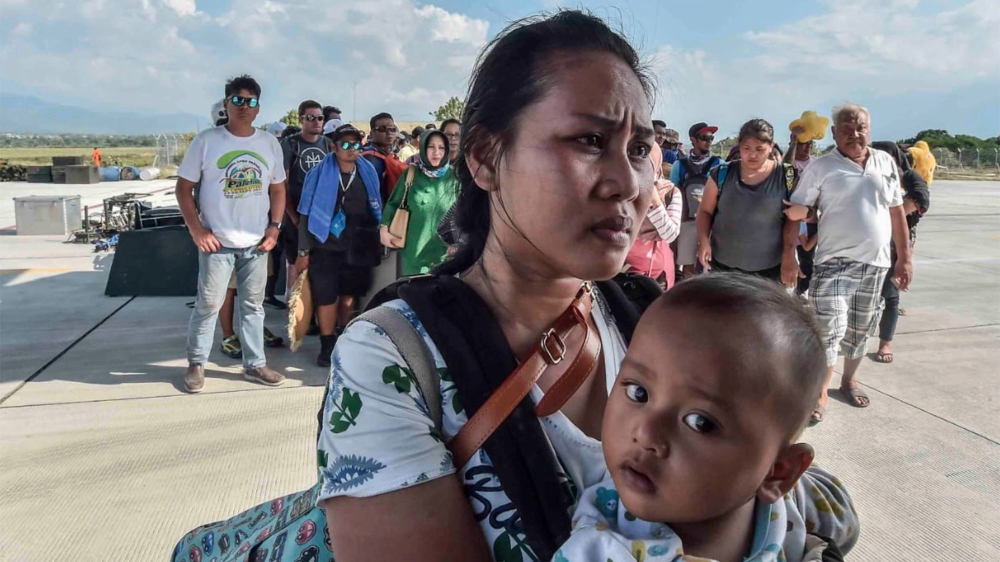 People injured or affected by the earthquake and tsunami wait to be evacuated on an air force plane in Palu, Central Sulawesi [Antara Foto/Muhammad Adimaja /Reuters]