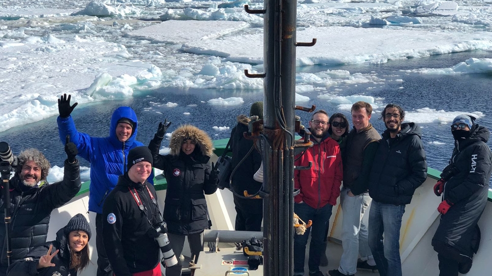 Ben Mitchell (bottom left) and part of the Arctic Sunrise crew on deck during the expedition [Ben Mitchell/Al Jazeera]