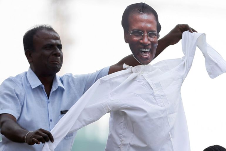 A supporter of Sri Lanka''s ousted Prime Minister Ranil Wickremesinghe dances with a puppet with Sri Lanka''s President Maithripala Sirisena''s picture during a protest against his removal