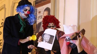 Protesters dressed as clowns perform during a protest opposing Prince Mohammed's visit [Asma Ajroudi/Al Jazeera]