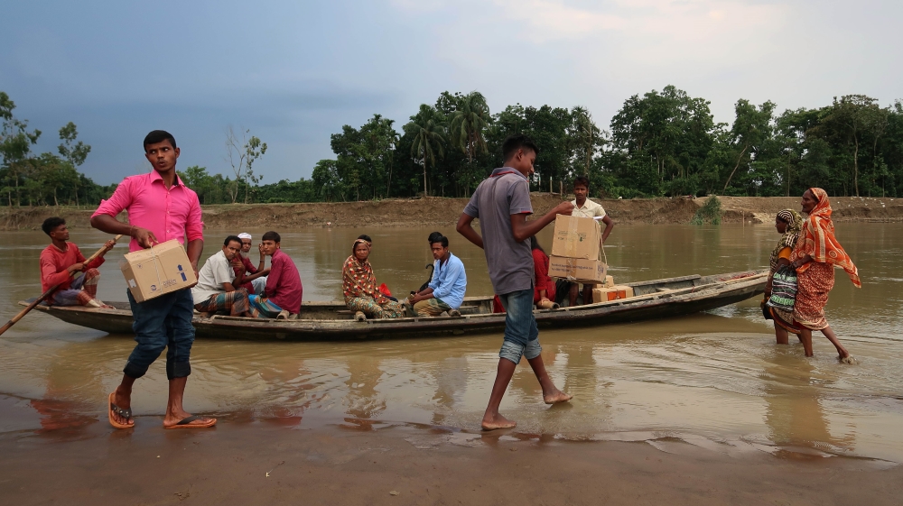 
Volunteers unloading boxes of medicine from a small boat crossing the river to get to the village [Jenny Gustafsson/Al Jazeera]
