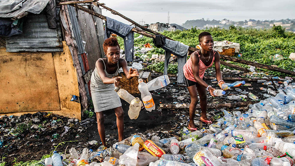 Children earn their living by recycling plastic soda bottles and cans [Marc Ellison/Al Jazeera]