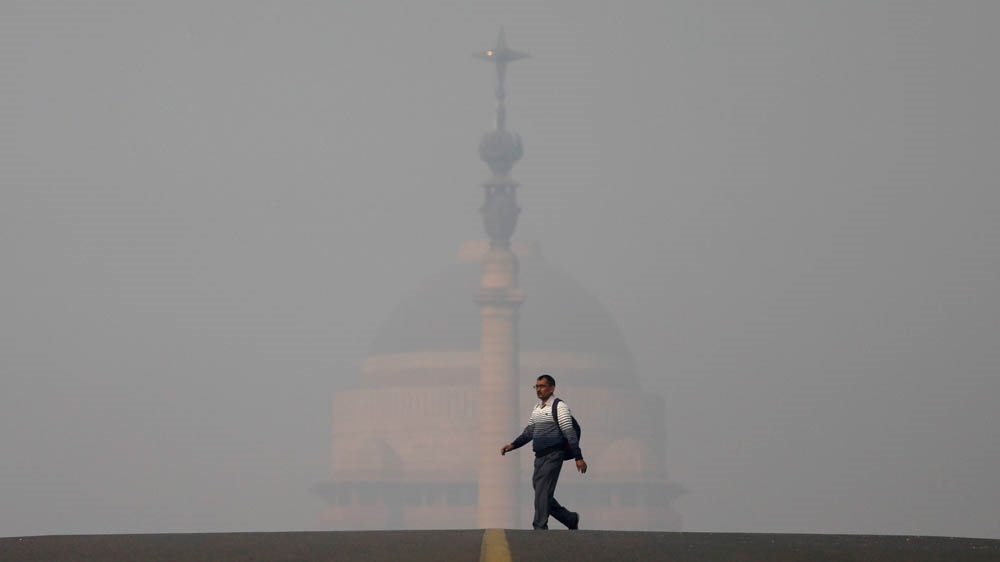 A man walks in front of the Indian president's official residence in New Delhi [Anushree Fadnavis/Reuters]