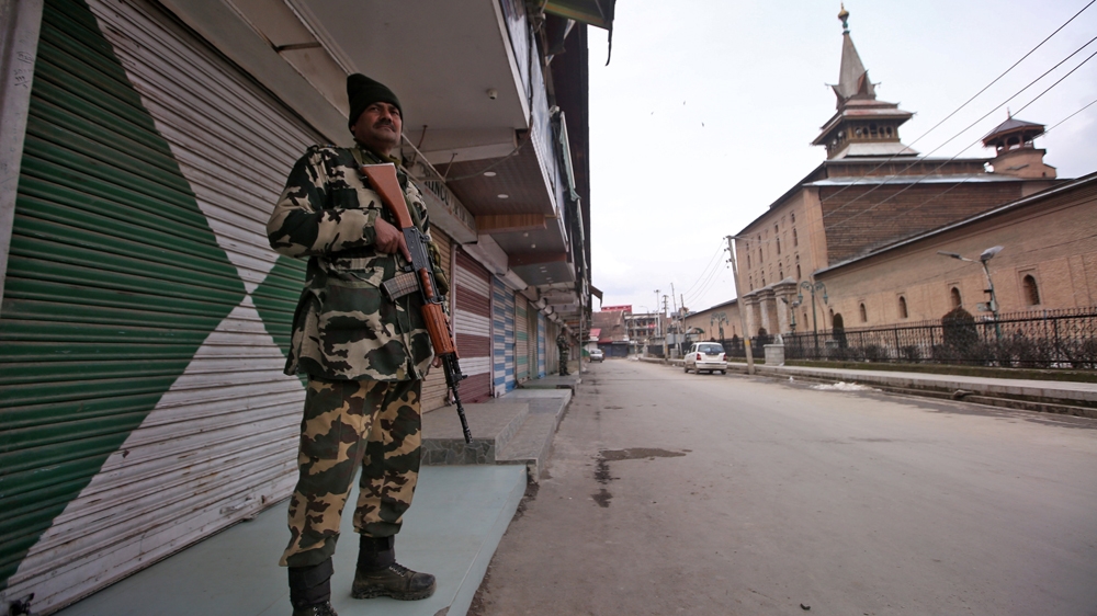 Indian Central Reserve Police Force personnel stands guard in front of closed shops next to the Jamai Masjid in Srinagar [Danish Ismail/Reuters]