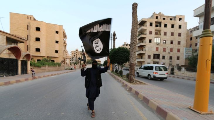 A member loyal to the Islamic State in Iraq and the Levant (ISIL) waves an ISIL flag in Raqqa, Syria June 29, 2014