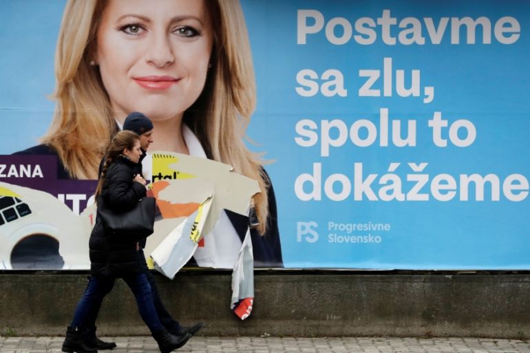 People walk past an election poster in Bratislava