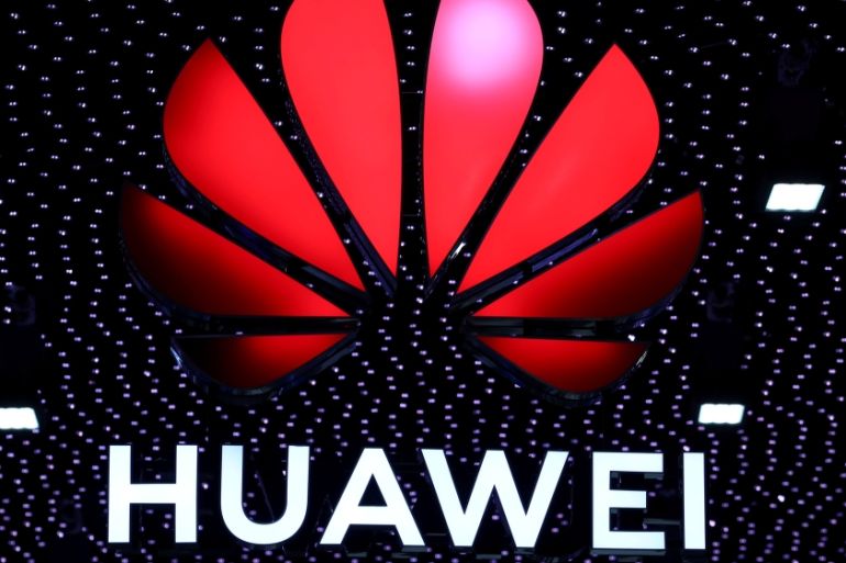 A 3D printed Huawei logo is placed on glass above a displayed U.S. flag in this illustration taken January 29, 2019