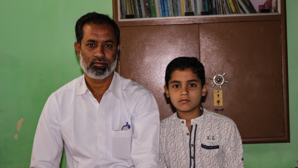 Farukh Ahmad Khan, seen with his son at their house in Bhusawal, lost his job as a lecturer; he struggled to rebuild his life after being accused of terrorism [Bilal Kuchay/Al Jazeera]
