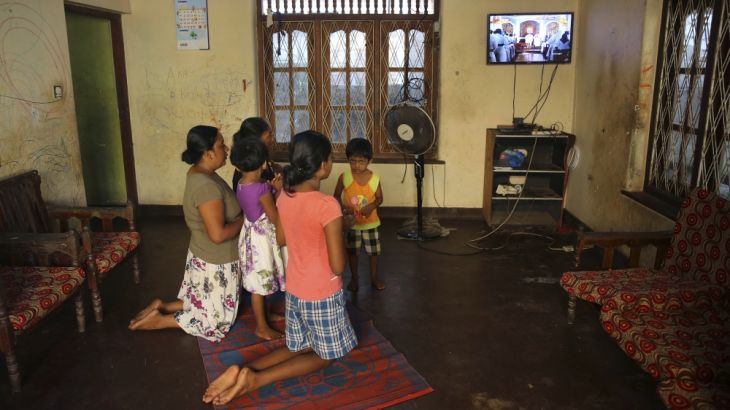 A Sri Lankan Christian catholic family prays inside their home watching live transmission of Sri Lankan Archbishop Cardinal Malcolm Ranjith, in Negombo, Sri Lanka, Sunday, April 28, 2019. Sri Lanka''s