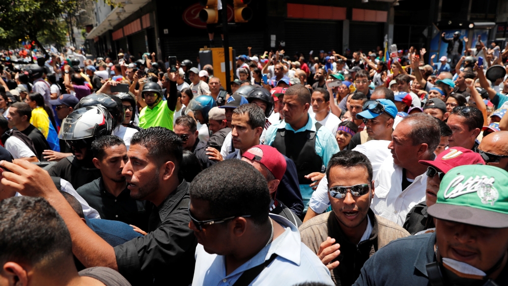 Venezuelan opposition leader Juan Guaido walks with supporters in Caracas [Carlos Garcia Rawlins /Reuters]