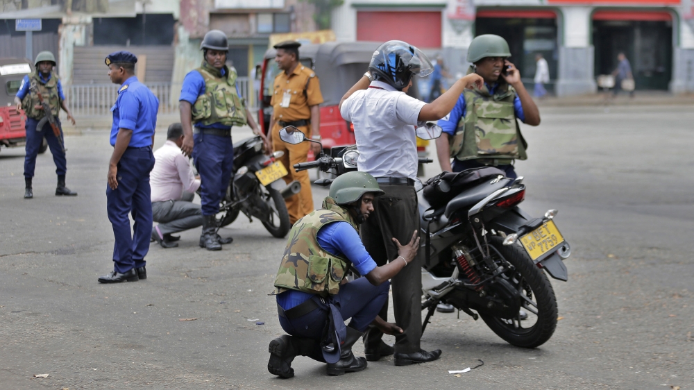 Sri Lankan soldiers perform security checks on motorists at a road in Colombo [Eranga Jayawardena/AP]
