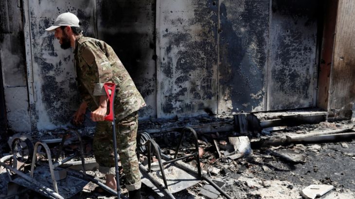 A wounded, fighter loyal to Libya''s U.N.-backed government (GNA) walks in front of a house burned during clashes with troops loyal to Khalifa Haftar in Wadi Rabiya neighbourhood at outskirts Tripoli