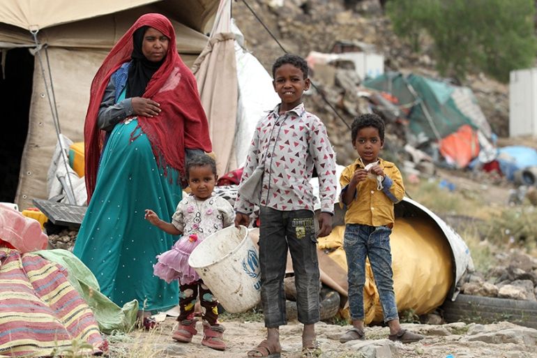 A displaced pregnant woman and her children stand outside a temporary shelter at a camp for Internally Displaced Persons (IDPs) on the outskirts of Sana''a, Yemen, 19 July 2019. According to reports, t