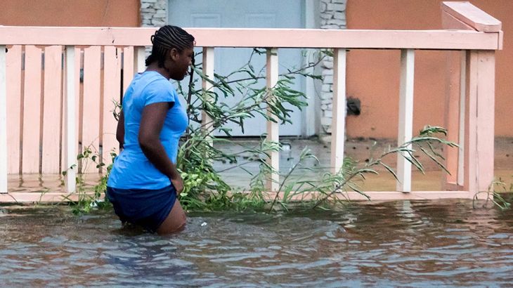 woman walks in a flooded street after the effects of Hurricane Dorian arrived in Nassau, Bahamas, September 2, 2019. REUTERS/John Marc