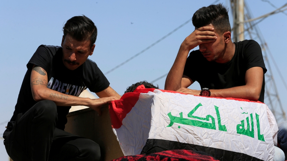 Iraqi men mourn over the coffin of a demonstrator who was killed at anti-government protests, during a funeral in the holy city of Najaf, Iraq October 5, 2019