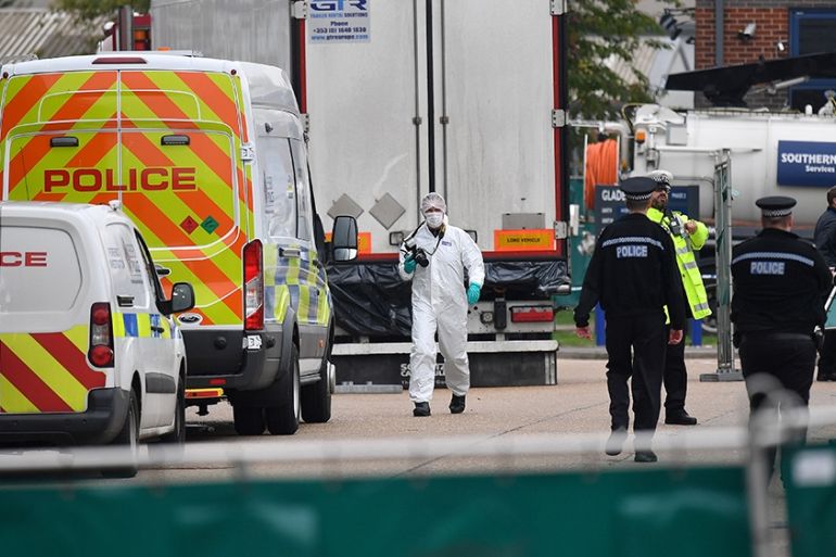 British Police officers in forsensic suits work near a lorry, found to be containing 39 dead bodies, as they work inside a police cordon at Waterglade Industrial Park in Grays, east of London, on Octo