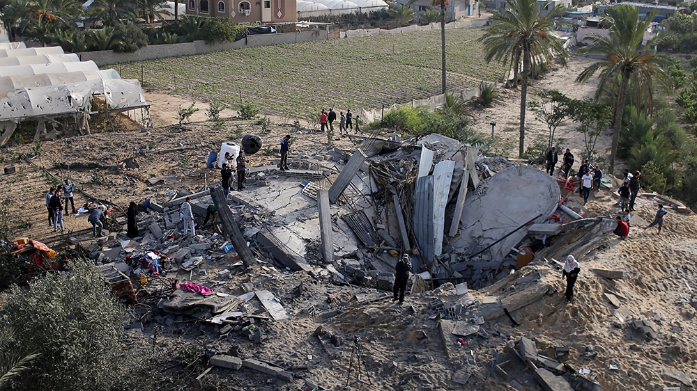 Palestinians gather around the remains of a house destroyed in an Israeli air strike in the southern Gaza Strip November 13, 2019. REUTERS/Ibraheem Abu Mustafa