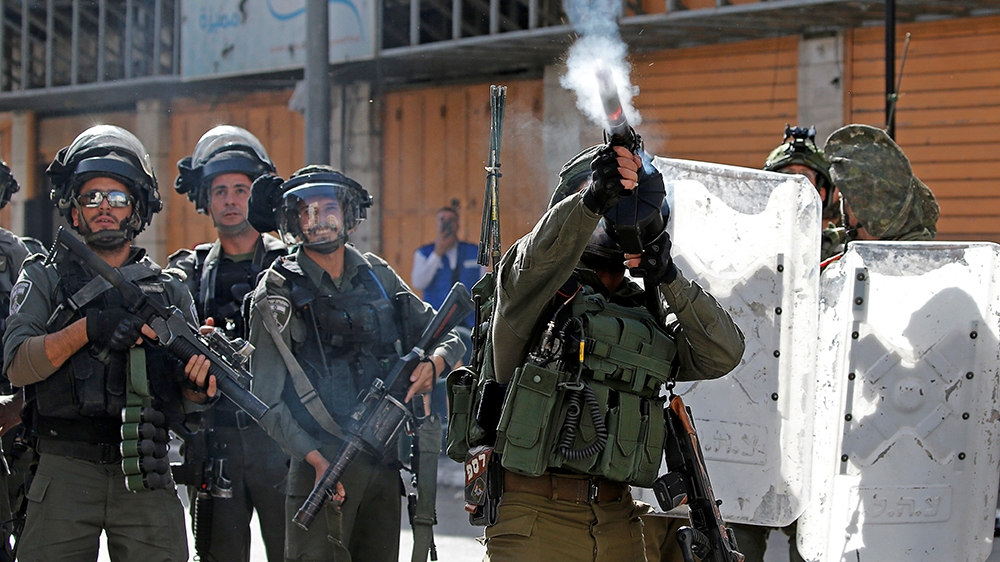 An Israeli soldier fires a weapon during a protest as Palestinians call for a day of rage over U.S. decision on Jewish settlements, in Hebron in the Israeli-occupied West Bank November 26, 2019. REUTE