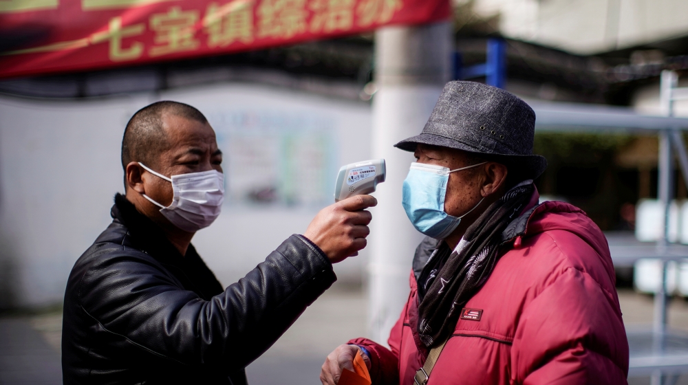 A man checks the temperature on a street in Qibao, an old river town on the outskirts of Shanghai, China, as the country is hit by an outbreak of the novel coronavirus, February 19, 2020. Picture take