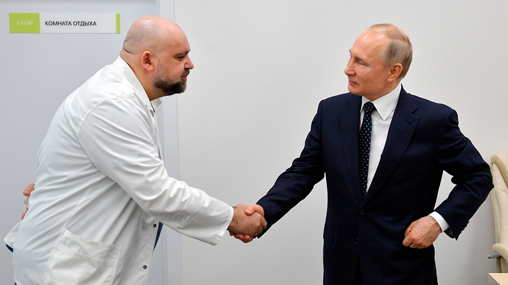 FILE In this file photo taken on Monday, March 23, 2020, Russian President Vladimir Putin, right shakes hands with the hospital's chief Denis Protsenko during his visit to the hospital for coronavirus